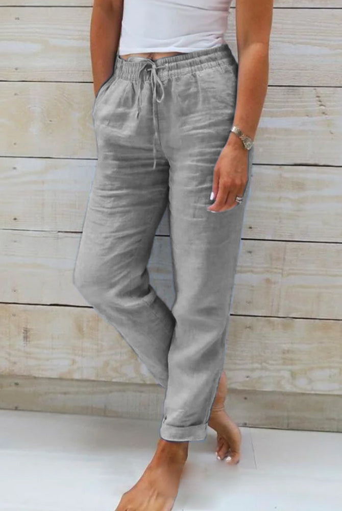 Lightweight beige linen trousers from Lumina Wear, styled for a sophisticated look, with a relaxed fit and elegant design.