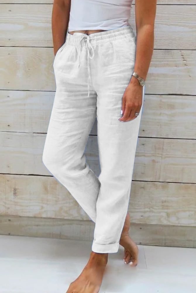 Lightweight beige linen trousers from Lumina Wear, model Isabella, featuring a relaxed fit and elegant design.