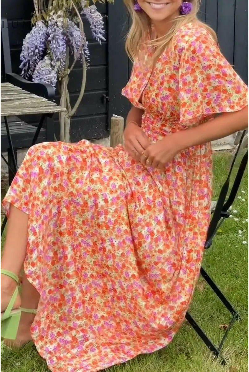 Orange Isabella maxi dress by Lumina Vancouver, perfect for wedding guest attire, shown on a model with elegant styling.