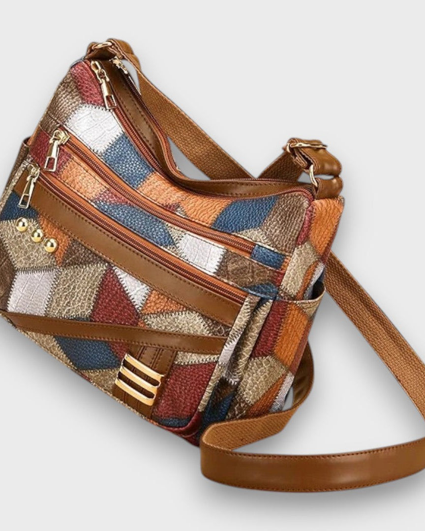 Lumina Wear Isabella textured patchwork shoulder bag with faux-leather accents, featuring a stylish handbag design and multiple compartments.