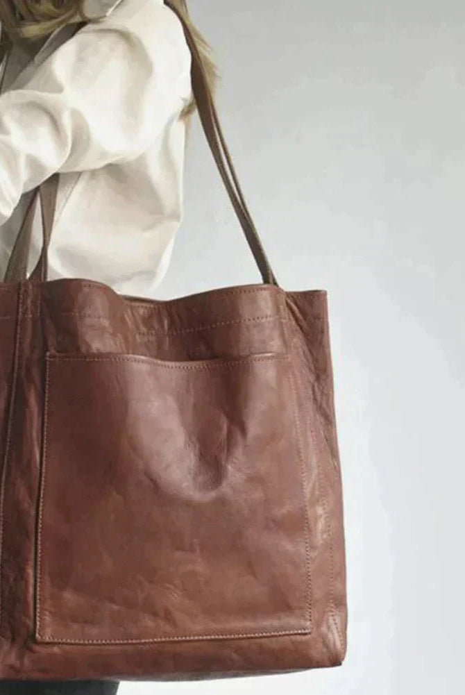 Elegant black leather handbag by Lumina Wear with spacious interior, featuring a structured design and durable leather material.