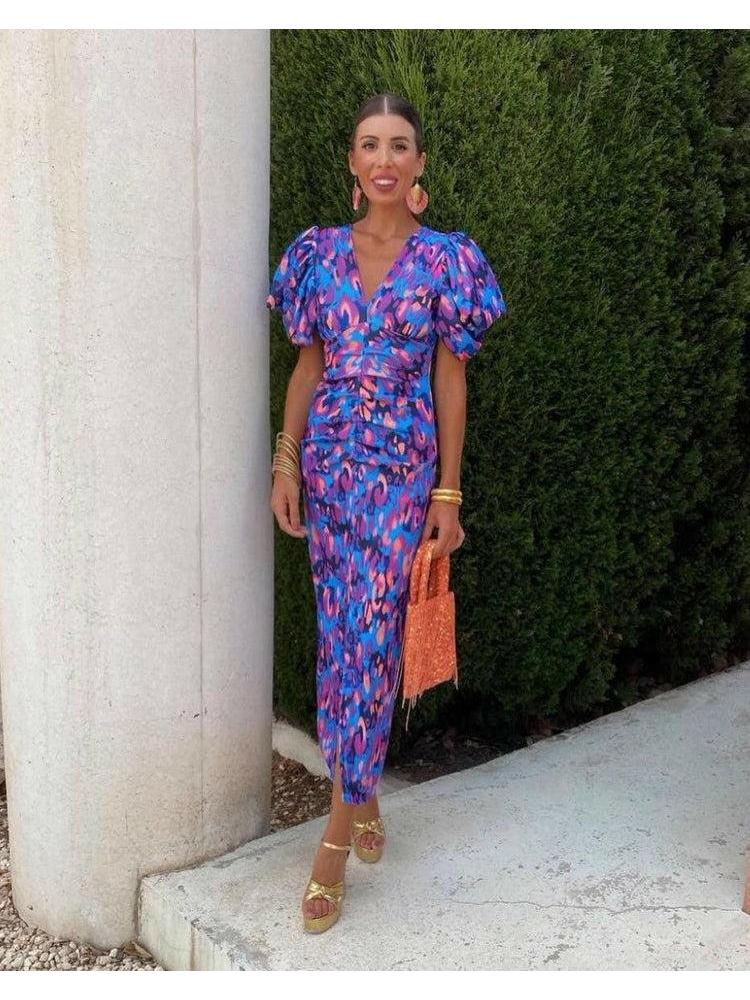 Purple Loren Vibrant Puff Sleeve Midi Dress by Lumina Vancouver displayed on a hanger with detailed puff sleeves and flowing fabric.