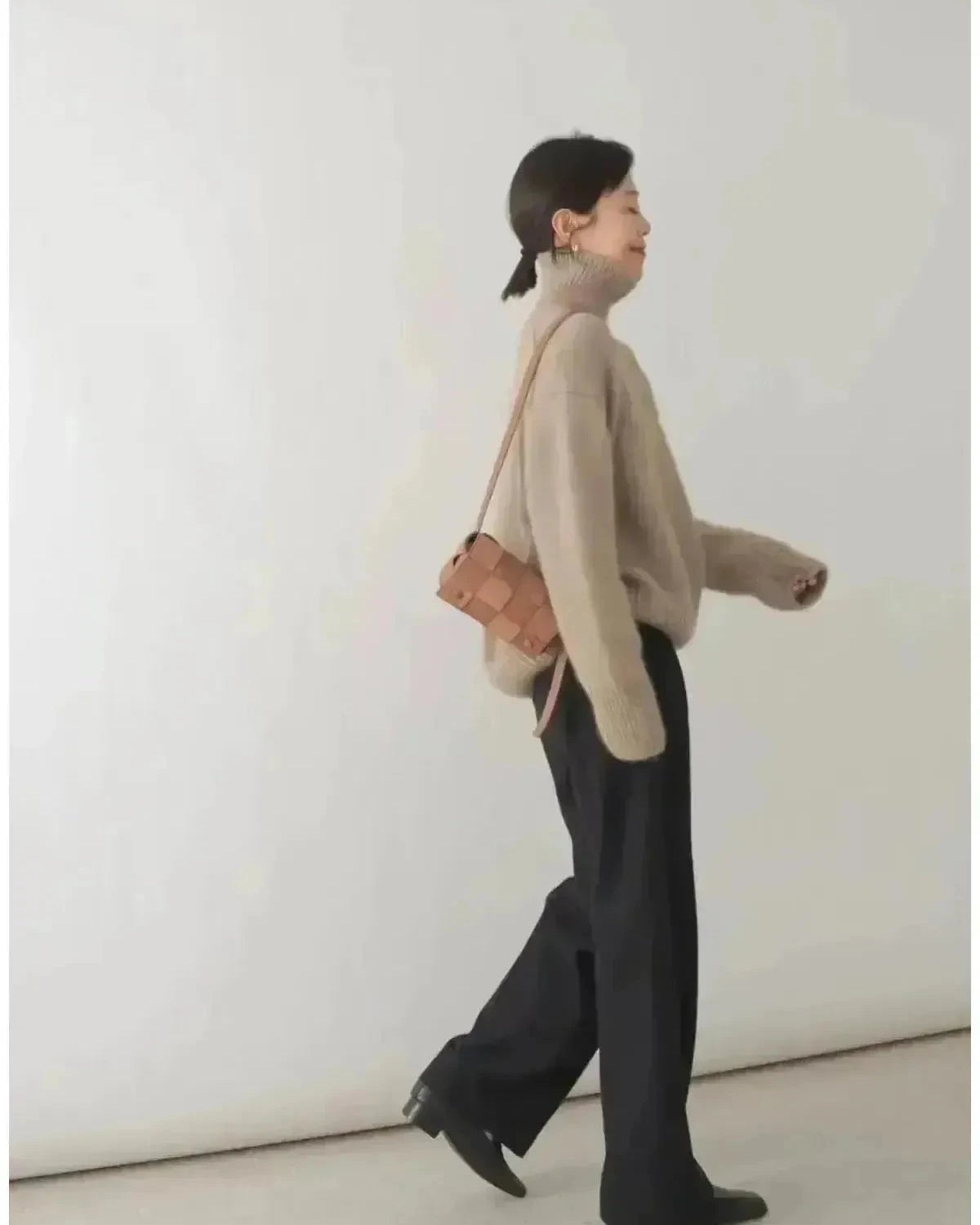 Beige Lumina Wear Lena turtleneck sweater displayed on a model, featuring a cozy fit and classic turtleneck design.