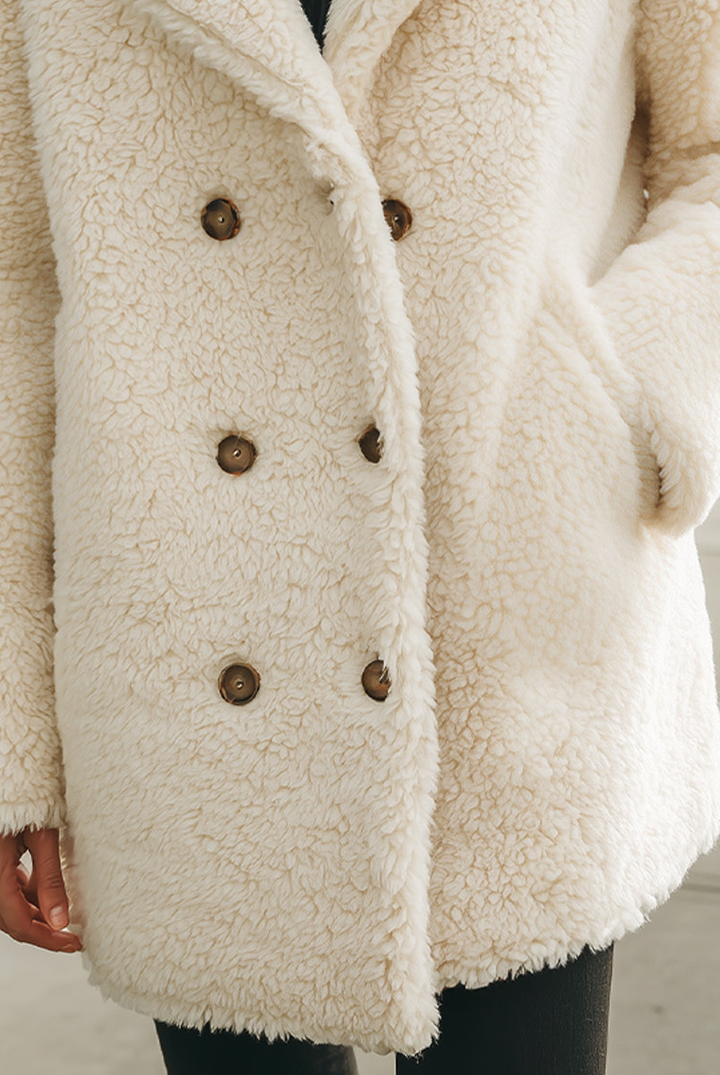 White Winifred double-breasted faux shearling coat by Lumina Vancouver, shown on a model with a cozy, stylish look.