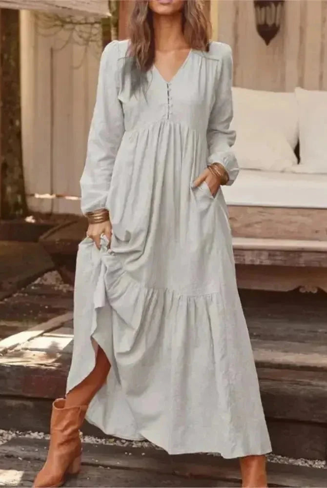 Light yellow Lumina Vancouver Giulia long sleeve dress displayed on a hanger, showcasing its elegant design and fabric details.