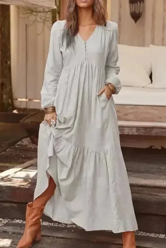 Light yellow Lumina Vancouver Giulia long sleeve dress displayed on a hanger, showcasing its elegant design and fabric details.