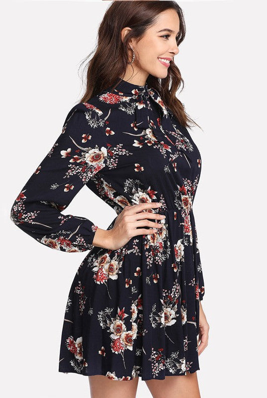 Dark blue Lumina Wear mini dress with floral Meadow Bloom pattern, featuring a fitted bodice and flowy skirt.