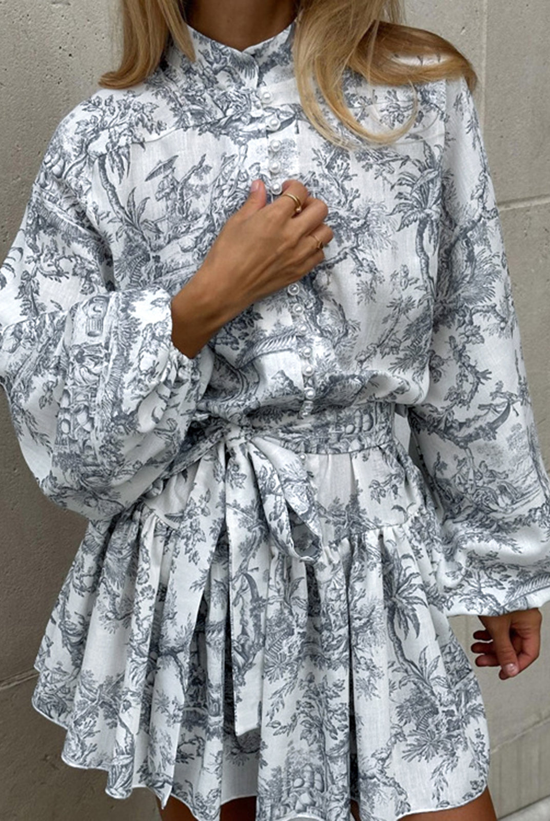 Grey Primrose A-line mini dress by Lumina Wear with Toile de Jouy print, shown on a model with a fitted waist and flared skirt.
