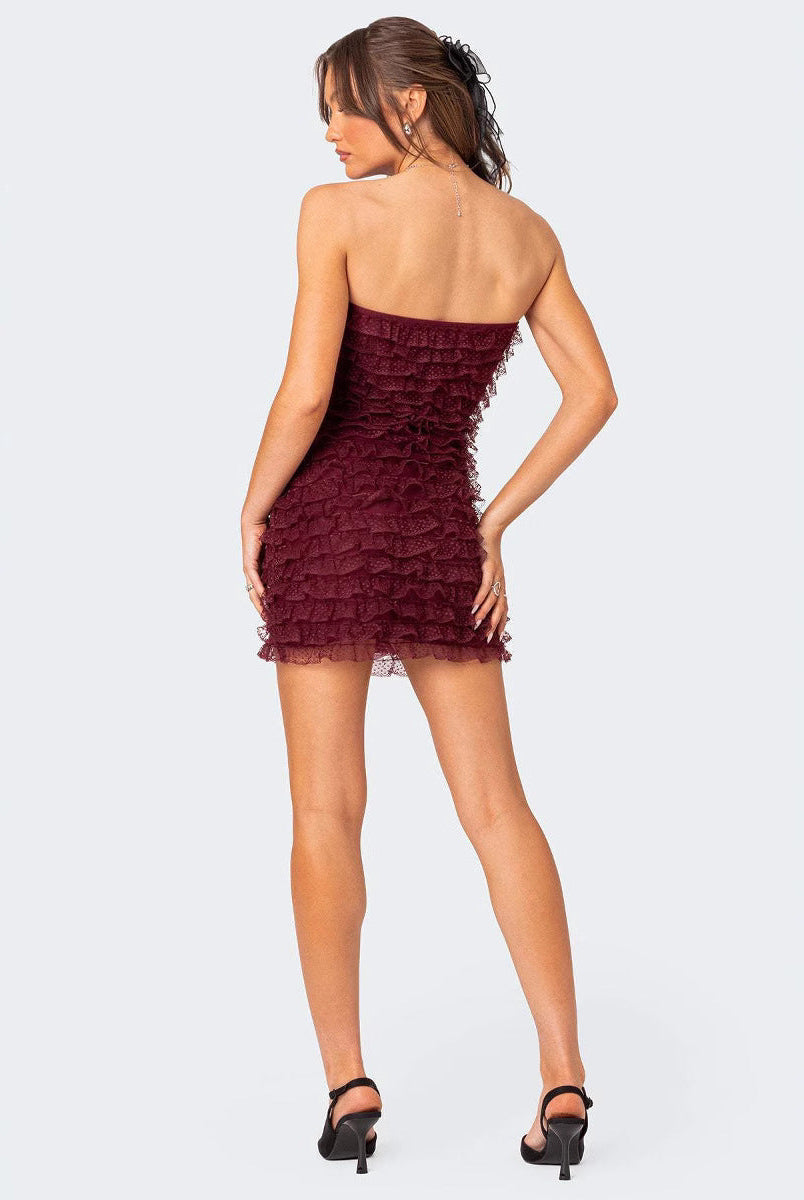 Red strapless ruffled mini dress by Lumina Wear featuring a fitted silhouette and flared hem, styled with elegant minimal details.