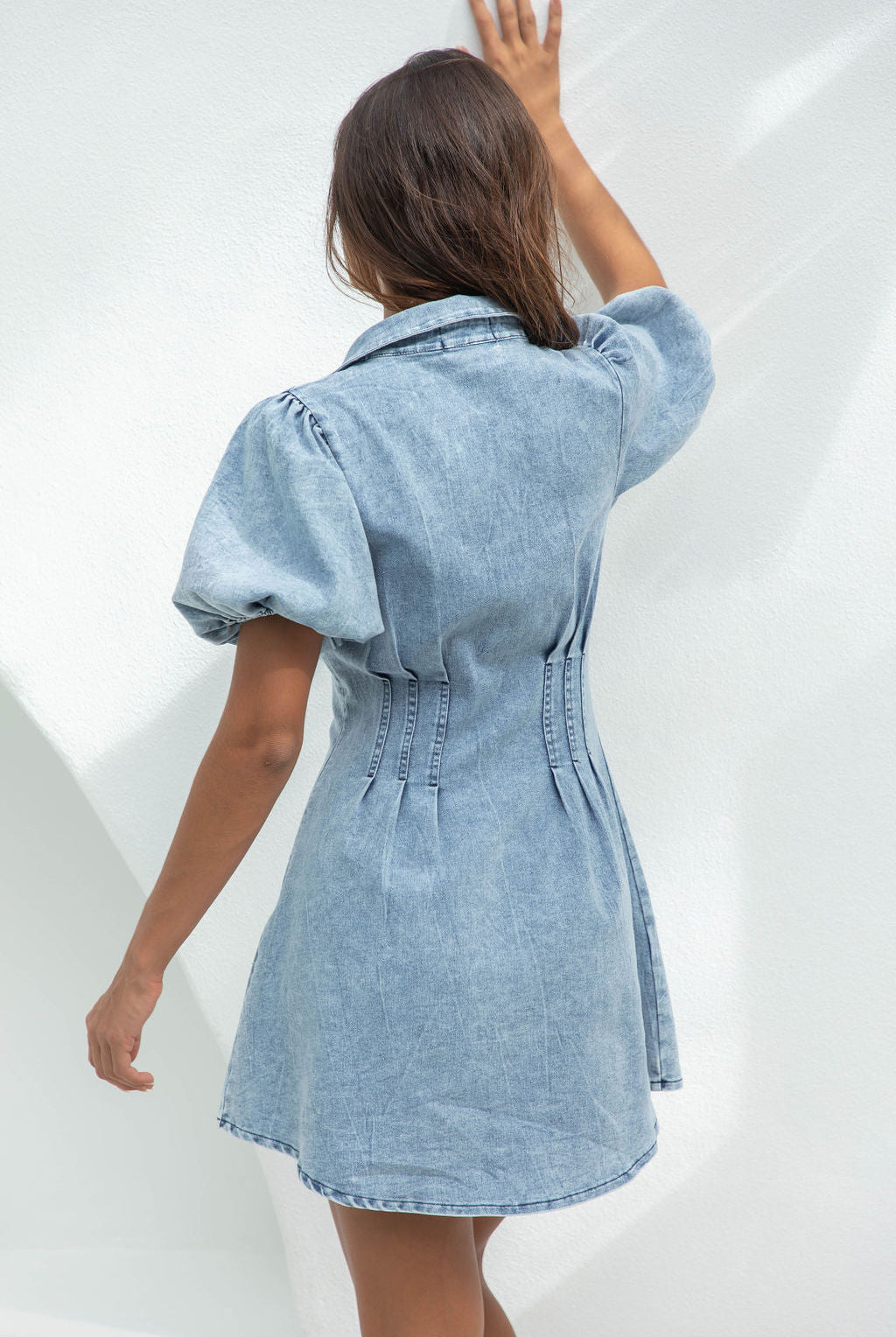 Lumina Vancouver Nova denim mini dress with button-down front, sleeveless style, and fitted silhouette.