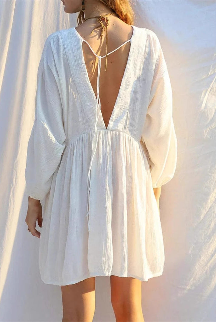 White Jacinta mini dress by Lumina Wear featuring a sheer V-neck and a free-size fit, showcased on a model.