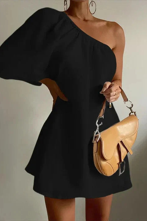 White Godeliève one-shoulder mini dress by Lumina Wear, featuring elegant shoulder design and fitted silhouette.