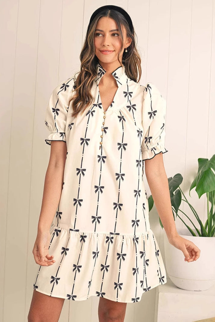 White Elara Cotton Bow Daydream A-line mini dress by Lumina Vancouver featuring a bow detail and classic A-line silhouette.