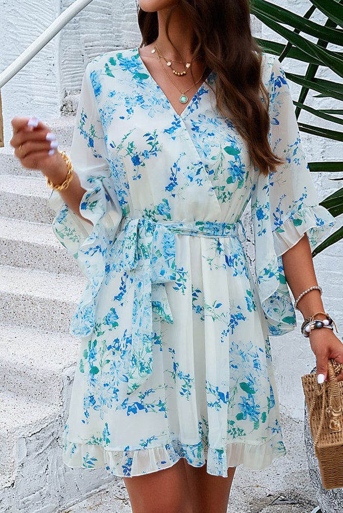 White women's floral V-neck mini dress by Lumina Wear, featuring a stylish and feminine design perfect for warm weather.