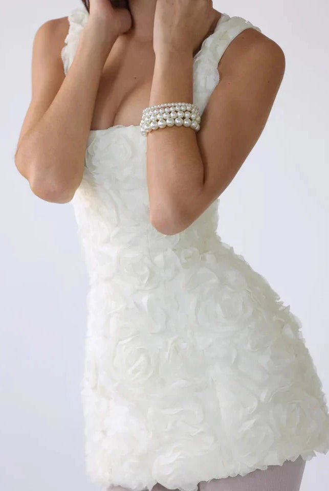 Lumina Wear Honoria mini dress with white 3D floral textured fabric, showcasing a stylish sleeveless design and fitted silhouette.