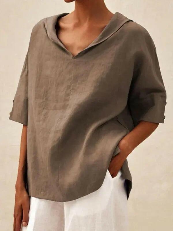 Blue women's casual V-neck shirt by Lumina Vancouver, displayed on a hanger, showcasing a comfortable, stylish everyday top.