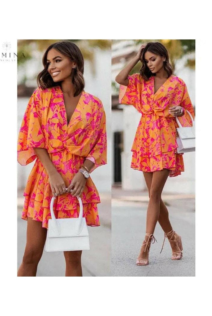 Valeria bohemian floral mini summer dress in orange and pink from Lumina Vancouver Summer Dress Collection, displayed on a hanger.