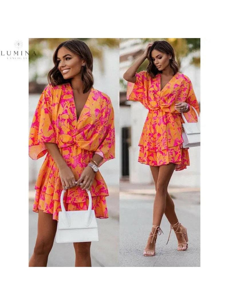 Valeria bohemian floral mini summer dress in orange and pink from Lumina Vancouver Summer Dress Collection, displayed on a hanger.