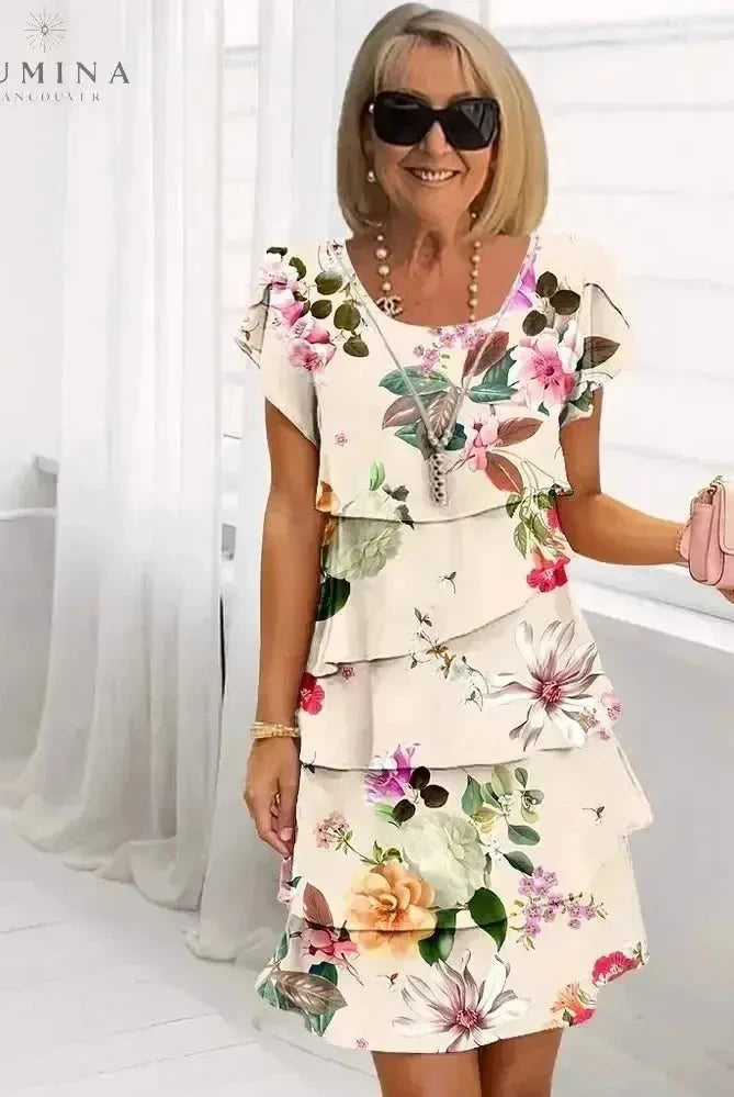 Lumina Wear Giselle floral dress featuring a white fabric with colorful floral patterns, sleeveless design, and a flattering fit.