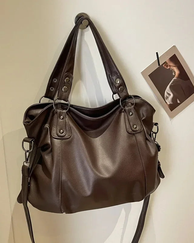 Lumina Wear Lunelle black handbag with spacious interior and versatile strap, shown with chocolate accents.