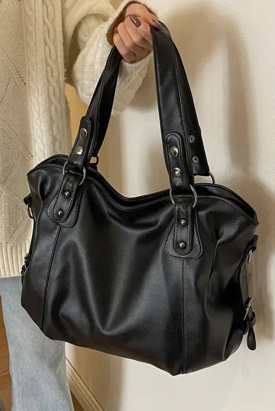 Lumina Wear Lunelle spacious black handbag with versatile strap, shown with chocolate accents and multiple compartments.