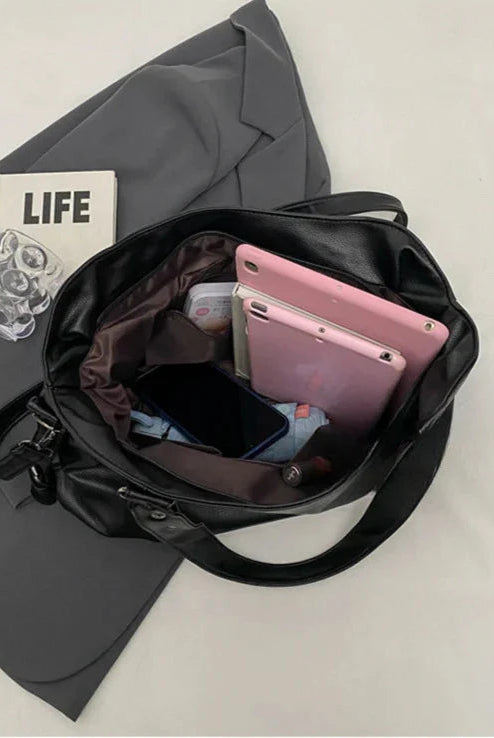 Lumina Wear Lunelle black handbag with spacious interior and versatile strap, made of sleek black material for stylish everyday use.