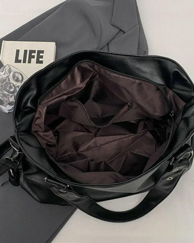 Lumina Wear Lunelle spacious black handbag with versatile strap, showing the stylish design and size of the hand-held accessory.