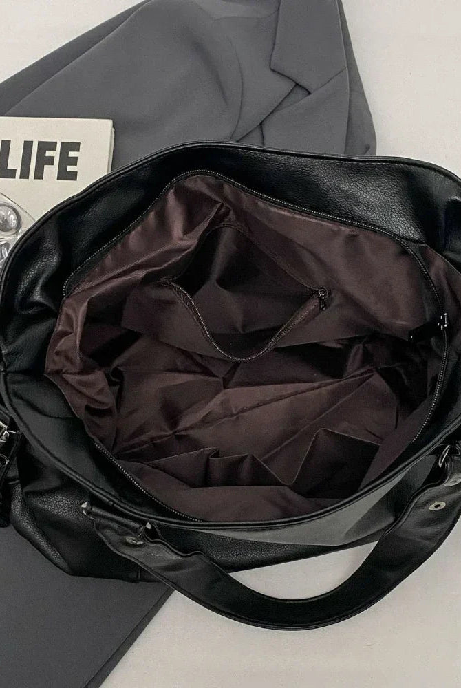 Lumina Wear Lunelle black handbag with spacious interior and versatile strap, shown with chocolate accents and stylish design.