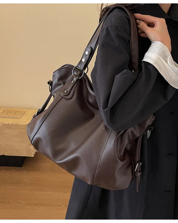 Black Lumina Wear Lunelle handbag with spacious interior and versatile strap, shown with chocolate accents on a white background.