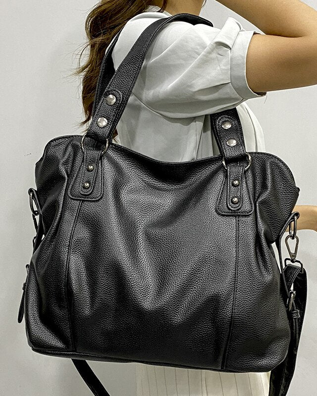 Black Lumina Wear Lunelle handbag with spacious interior and versatile strap, shown with chocolate accents and stylish design.