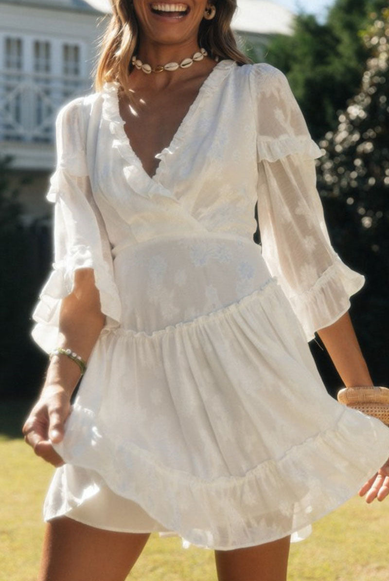 Suzette Lumina V-Neck Floral Print Mini Dress in white, featuring a fitted silhouette and vibrant floral pattern.