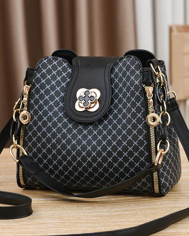 Black Lumina Wear Marjorie quilted handbag with adjustable strap, featuring elegant charm detailing and compact design.