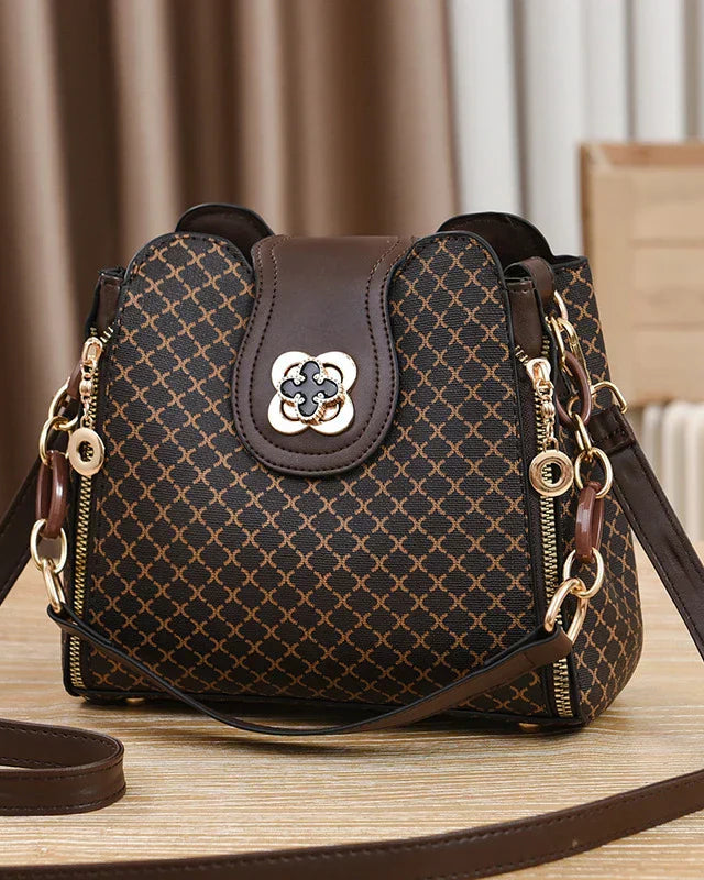 Black Marjorie Lumina Wear quilted charm handbag with adjustable strap, elegant design and structured silhouette.