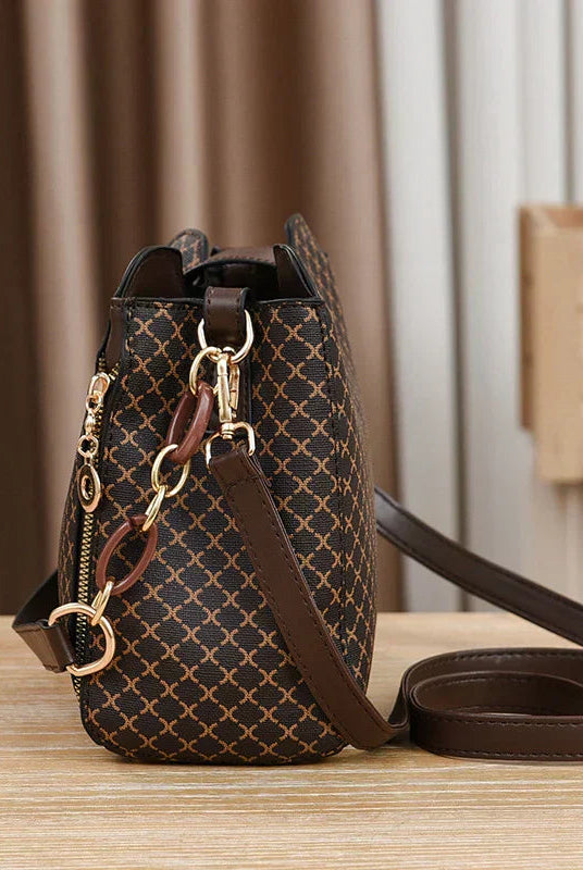 Black Marjorie quilted charm handbag with adjustable strap by Lumina Wear, featuring elegant stitching and compact design.