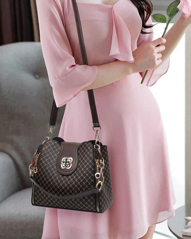 Black Lumina Wear Marjorie quilted charm handbag with adjustable strap, elegant design and compact size.