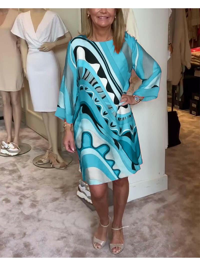 Mirabella™ Vibrant Abstract Print Dress in coral pink by Lumina Vancouver, showcasing bold, colorful patterns and flowing fabric.