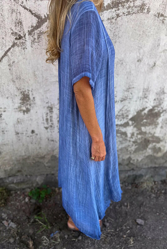 Blue Lumina Wear NIA maxi dress displayed on a hanger, showcasing its flowing fabric and elegant design.