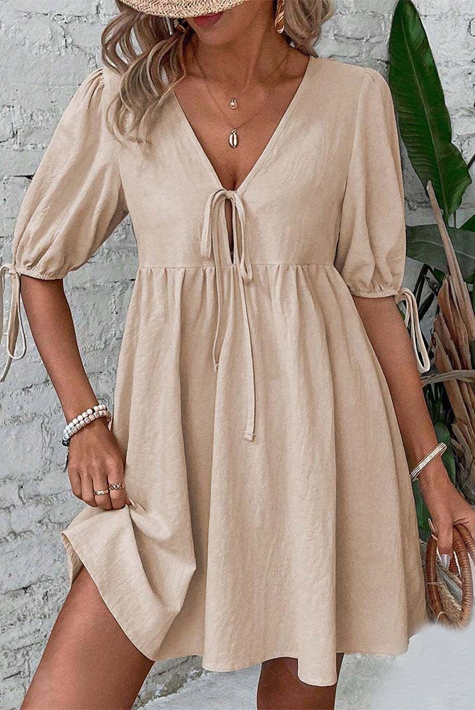 Aly's khaki A-line mini dress with deep V-neck by Lumina Wear, styled casually on a model.