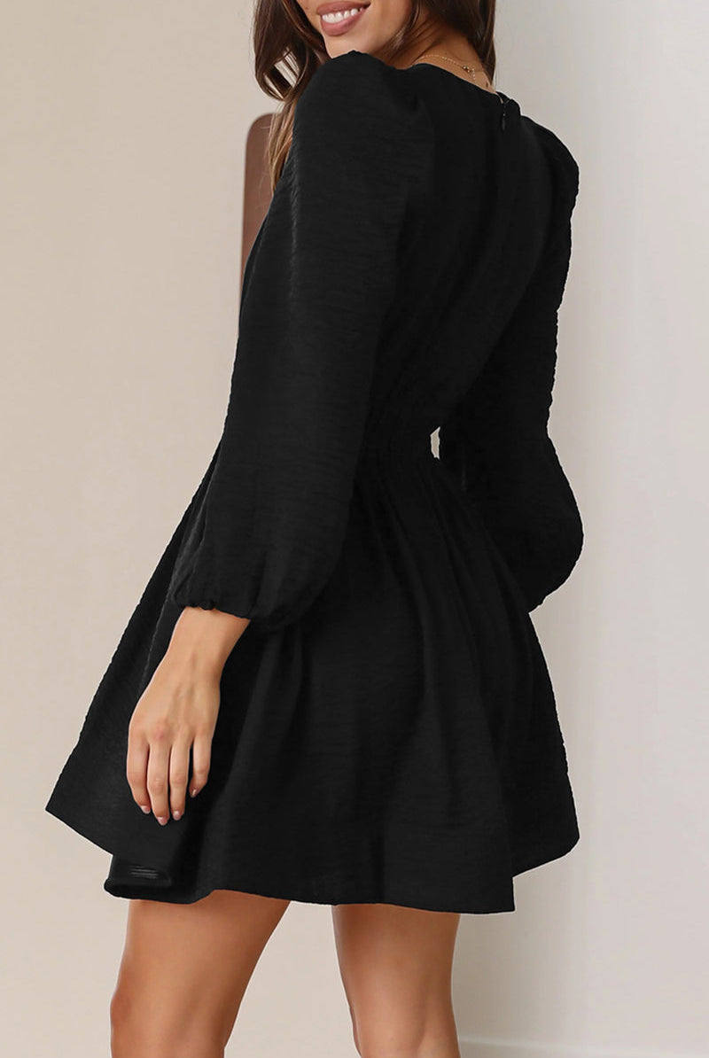 Black Nova mini dress by Lumina Vancouver featuring a V-neck and puff sleeves, shown on a model.