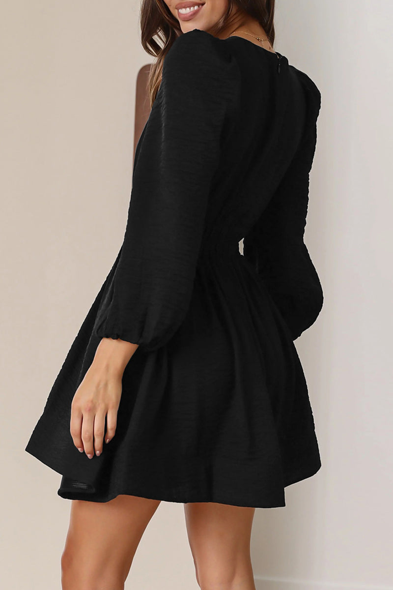 Black Nova mini dress by Lumina Vancouver featuring a V-neck and puff sleeves, shown on a model.