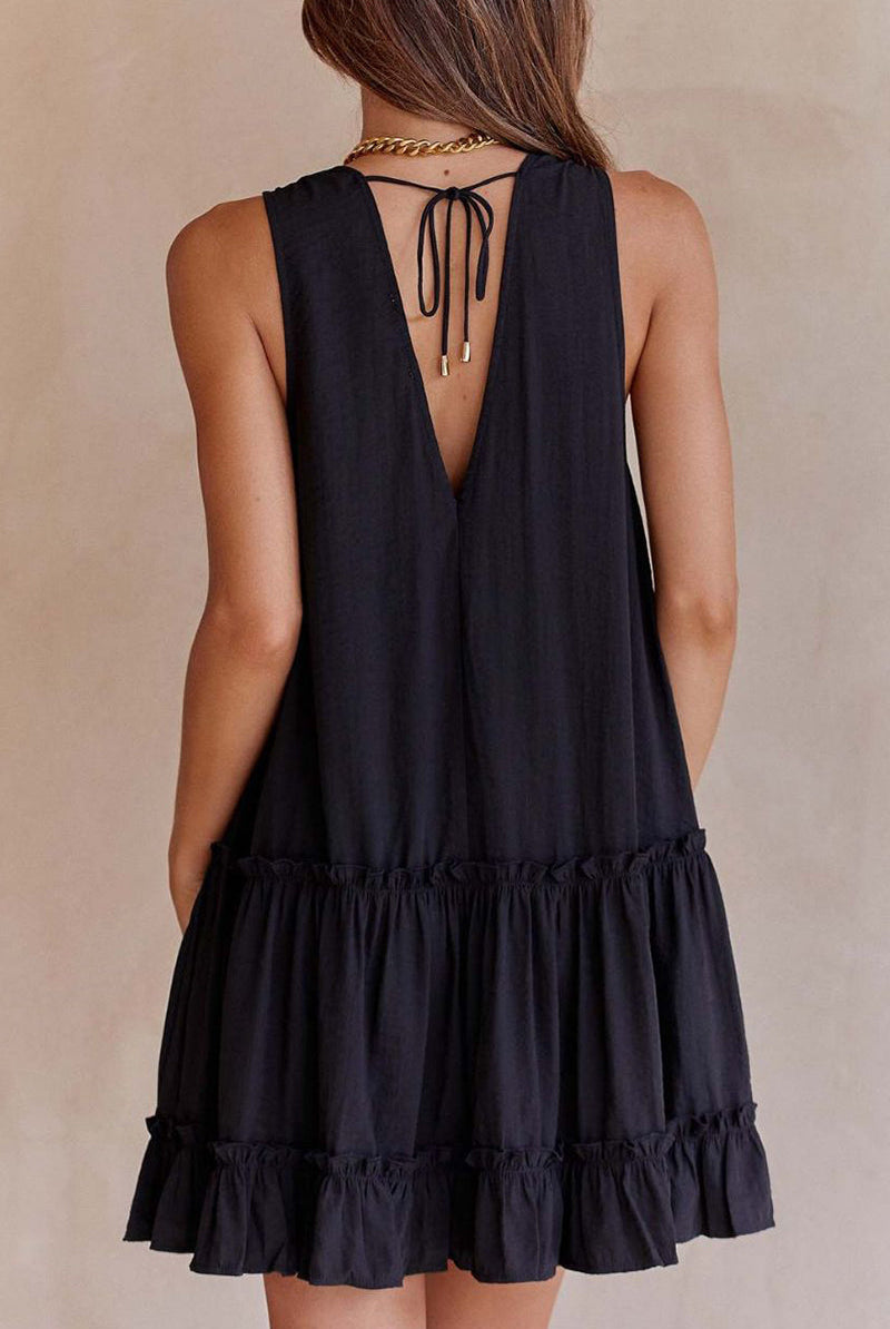 Black Lumina Wear Emer sleeveless ruffle mini dress with deep V-neck, shown on a model.