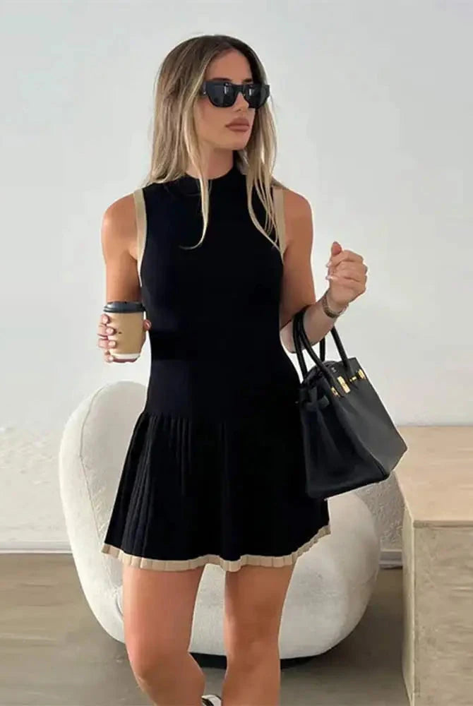 Black Nova sleeveless pleated mini dress by Lumina Vancouver, showcasing a stylish mini dress with pleats and sleeveless design.