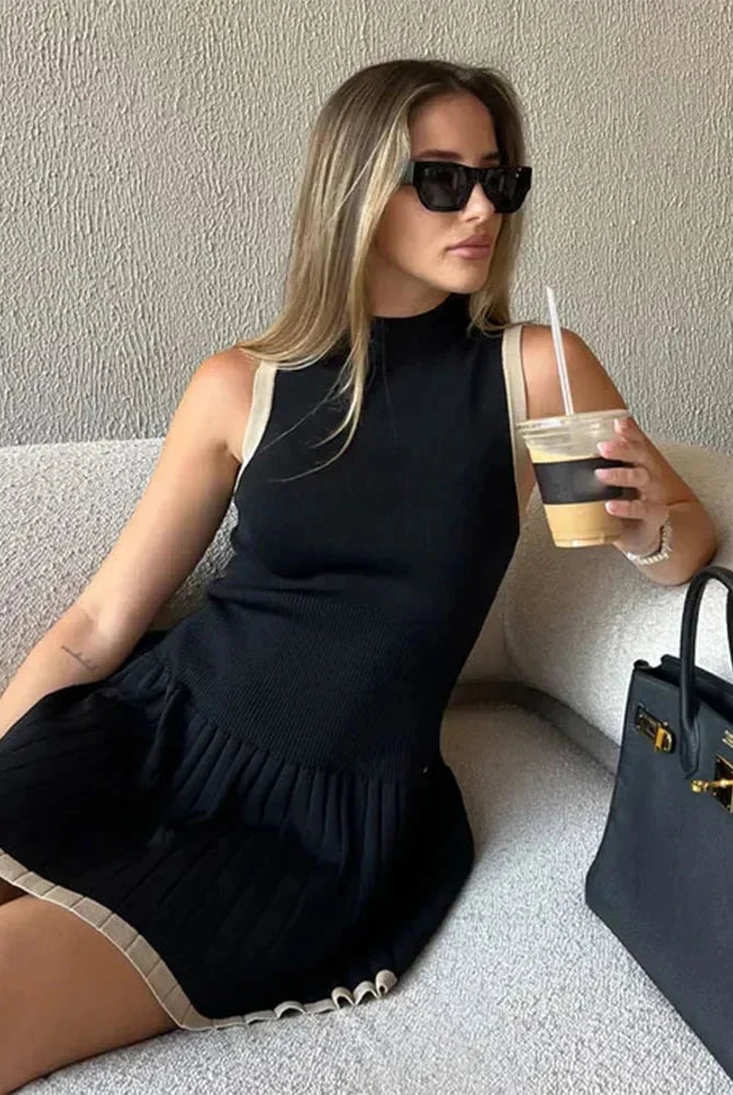 Black Nova sleeveless pleated mini dress by Lumina Vancouver, featuring a fitted bodice and flowy pleated skirt.