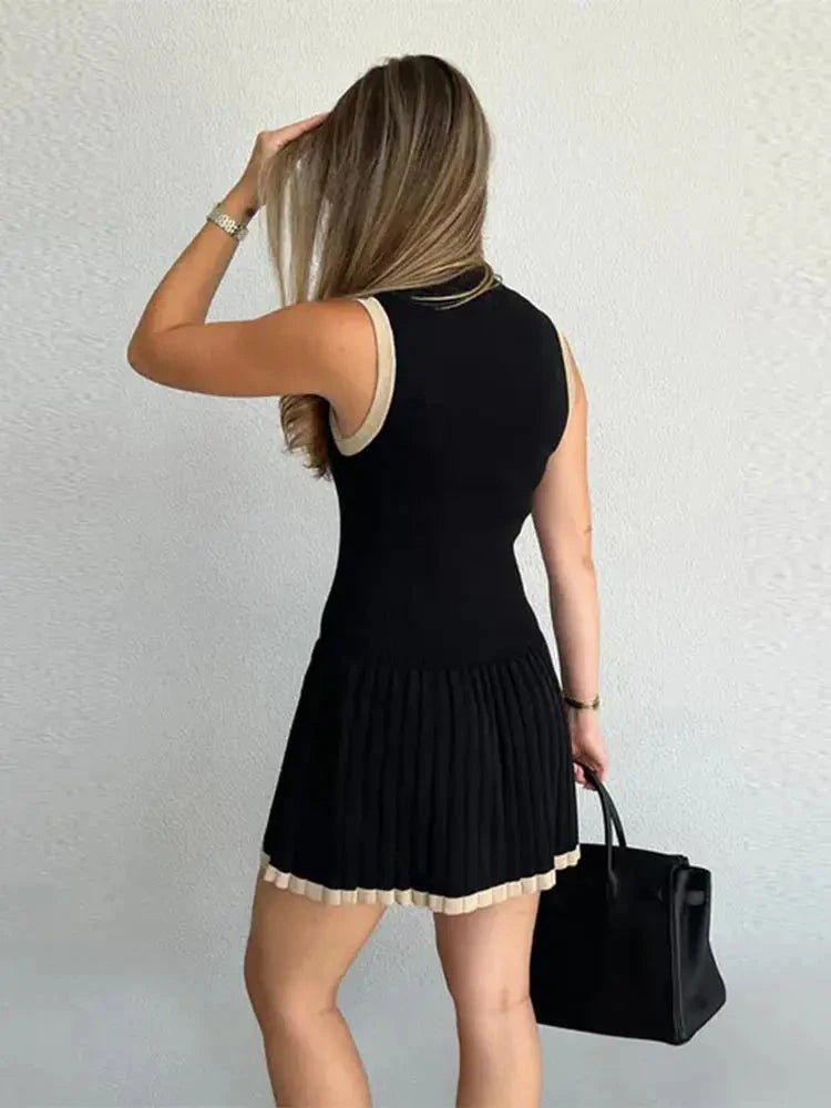 Black Nova sleeveless pleated mini dress by Lumina Vancouver, featuring a stylish short design with a fitted bodice and pleated skirt.