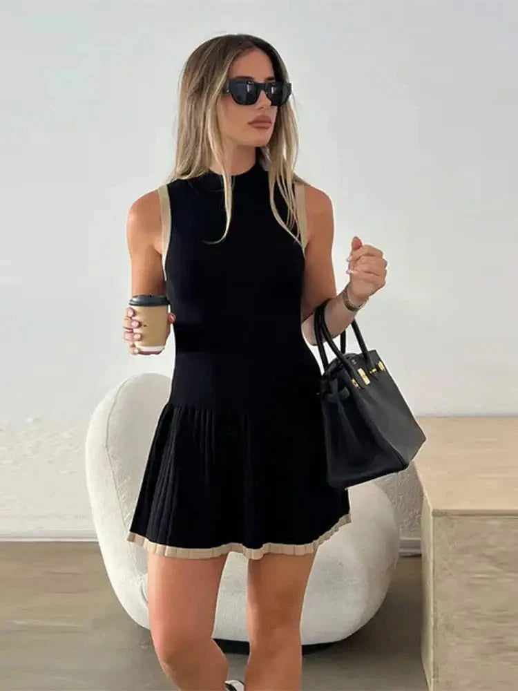 Black Nova sleeveless pleated mini dress by Lumina Vancouver, showcasing a stylish, lightweight design with a fitted bodice and flared skirt.