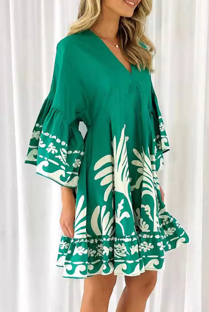Green Nova V-neck A-line boho print mini dress by Lumina Vancouver displayed on a hanger.
