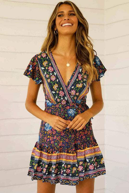 Blue floral print Gwyn wrap mini dress by Lumina Wear, shown on a model with a fitted silhouette and elegant design.