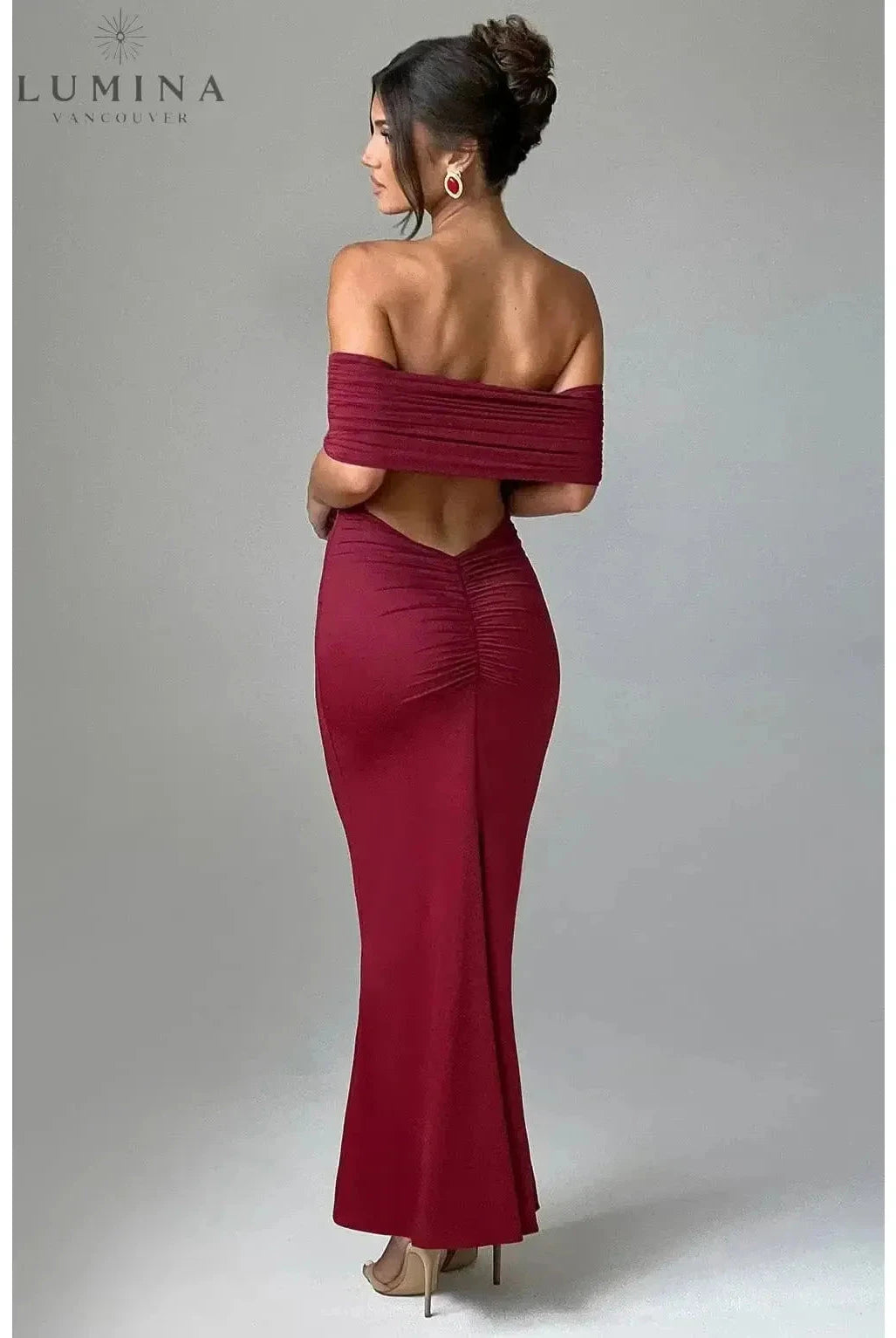 Black Olympia Lumina Wear backless maxi dress featuring a fitted silhouette perfect for wedding guests.