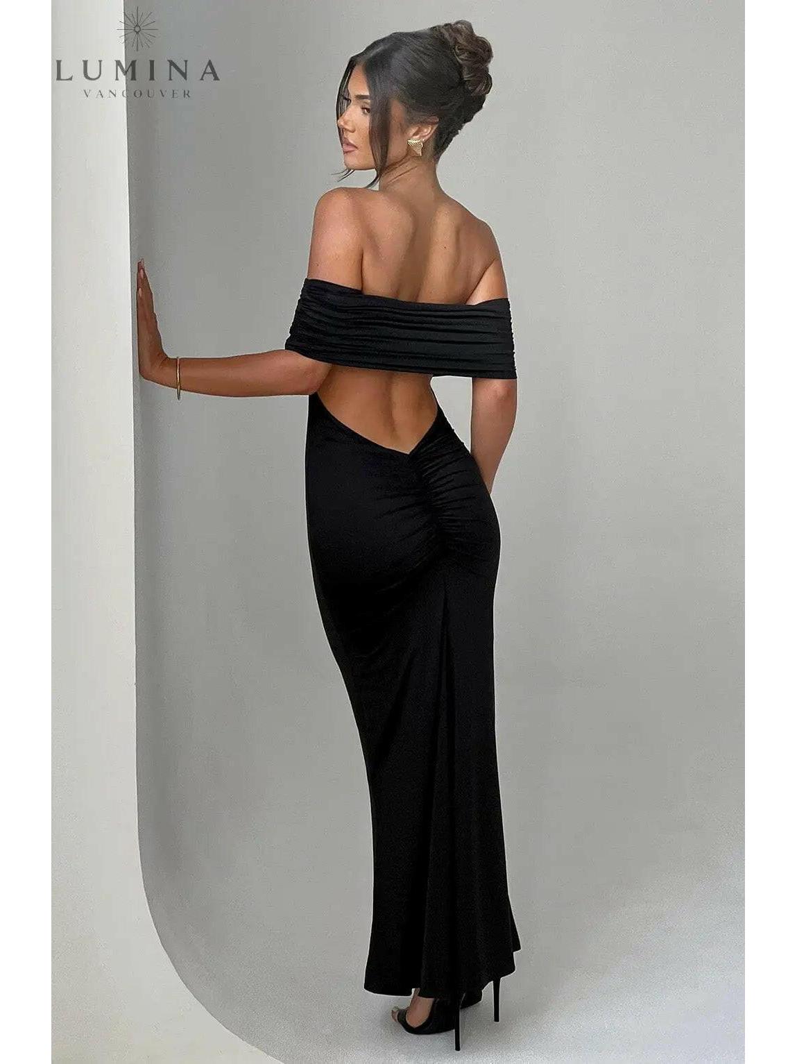 Black Olympia backless maxi dress by Lumina Vancouver, elegant wedding guest gown with flowing silhouette, perfect for formal occasions.