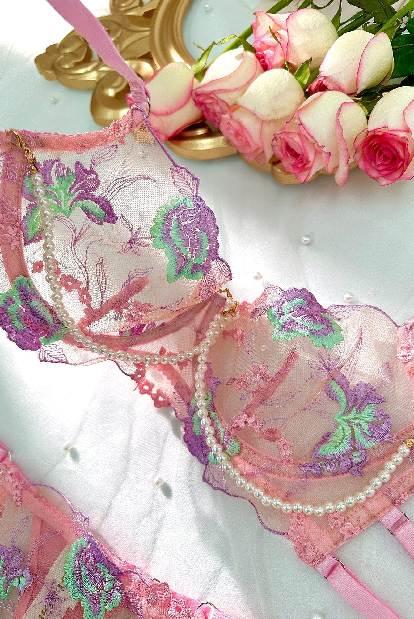 Pink floral embroidery lingerie set with pearl chain details, featuring matching bras and panties from Lumina Wear.